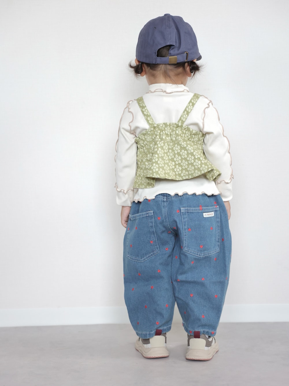 ベージュ系のスニーカー、グリーン系のTシャツ/カットソー、ブルー系のデニムパンツを着用したキッズの夏コーディネートの3枚目の写真