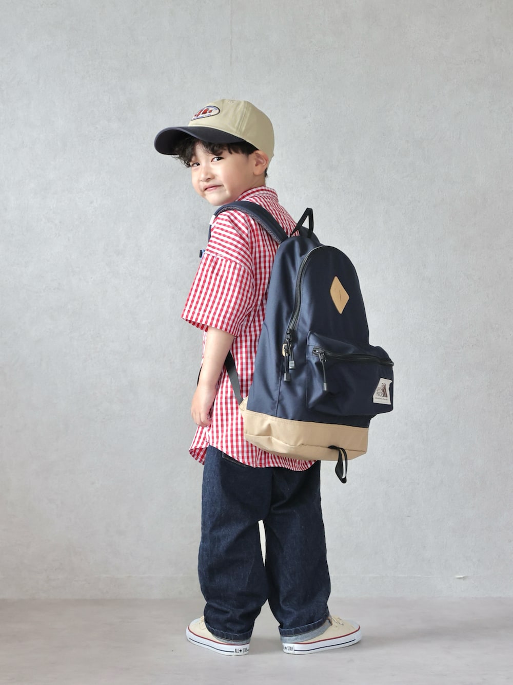 レッド系のシャツ/ブラウス、ブルー系のデニムパンツ、ホワイト系のスニーカーを着用したキッズの春コーディネートの2枚目の写真