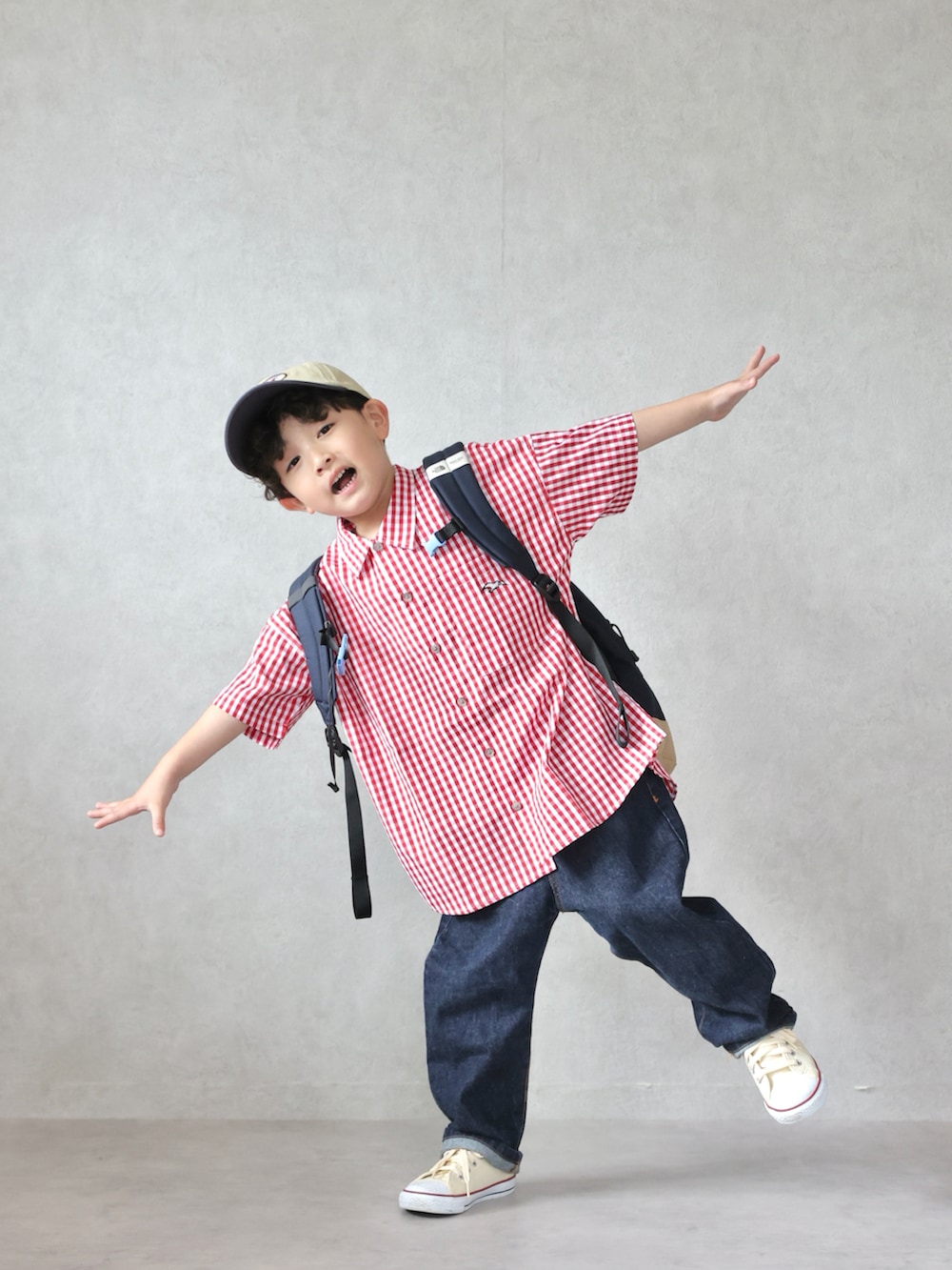 レッド系のシャツ/ブラウス、ブルー系のデニムパンツ、ホワイト系のスニーカーを着用したキッズの春コーディネートの3枚目の写真