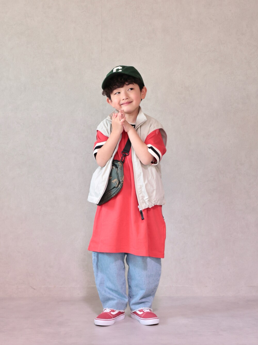 レッド系のワンピース、ブルー系のデニムパンツ、レッド系のスニーカーを着用したキッズの春コーディネートの5枚目の写真