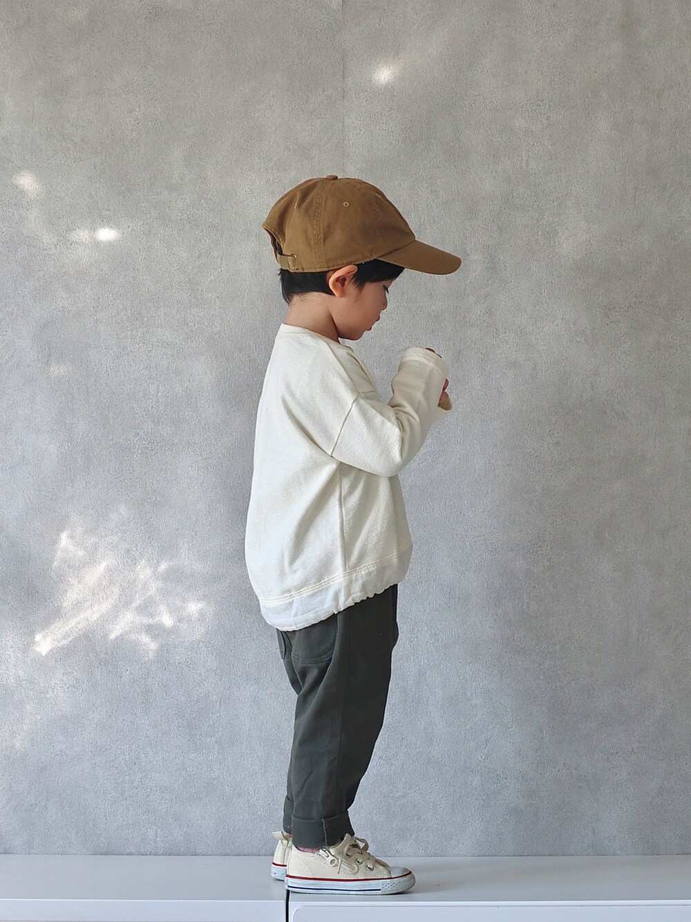 ブラウン系のカーディガン/ボレロ、ホワイト系のTシャツ/カットソー、グリーン系のその他パンツを着用したキッズの冬コーディネートの4枚目の写真