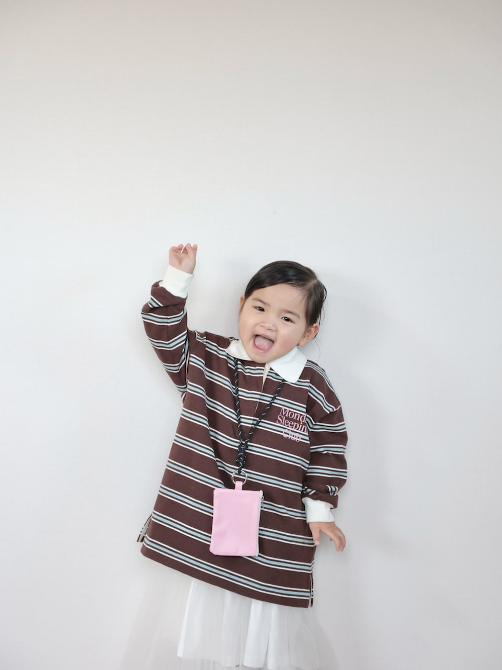 ブラウン系のポロシャツ、ホワイト系のスニーカー、ホワイト系のスカートを着用したキッズの春コーディネートの4枚目の写真