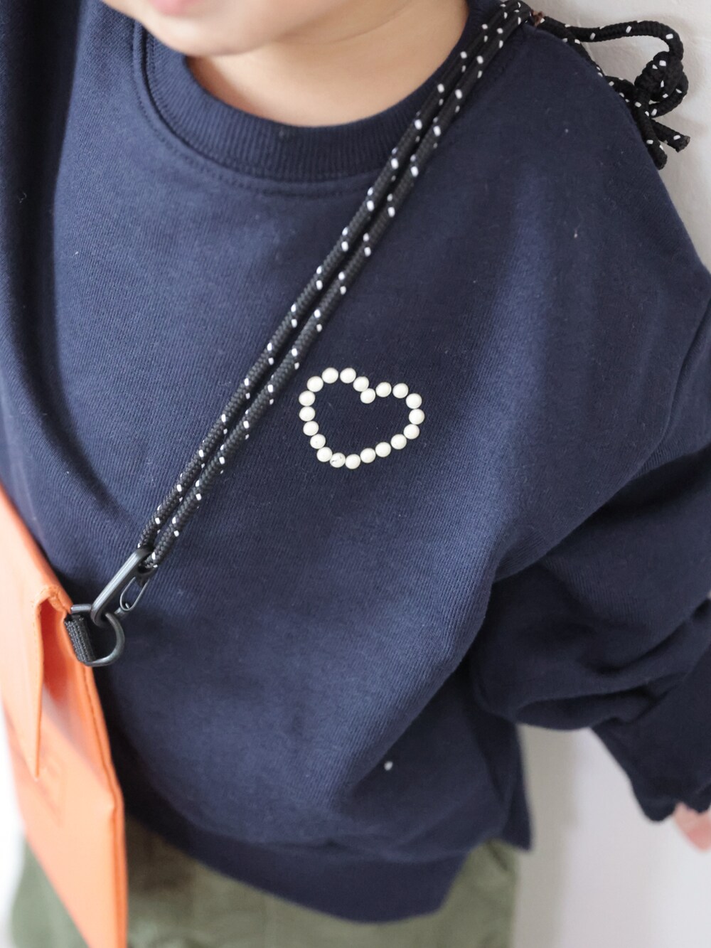 ブルー系のスウェット、グリーン系のパンツ、グレー系のスニーカーを着用したキッズの秋コーディネートの4枚目の写真