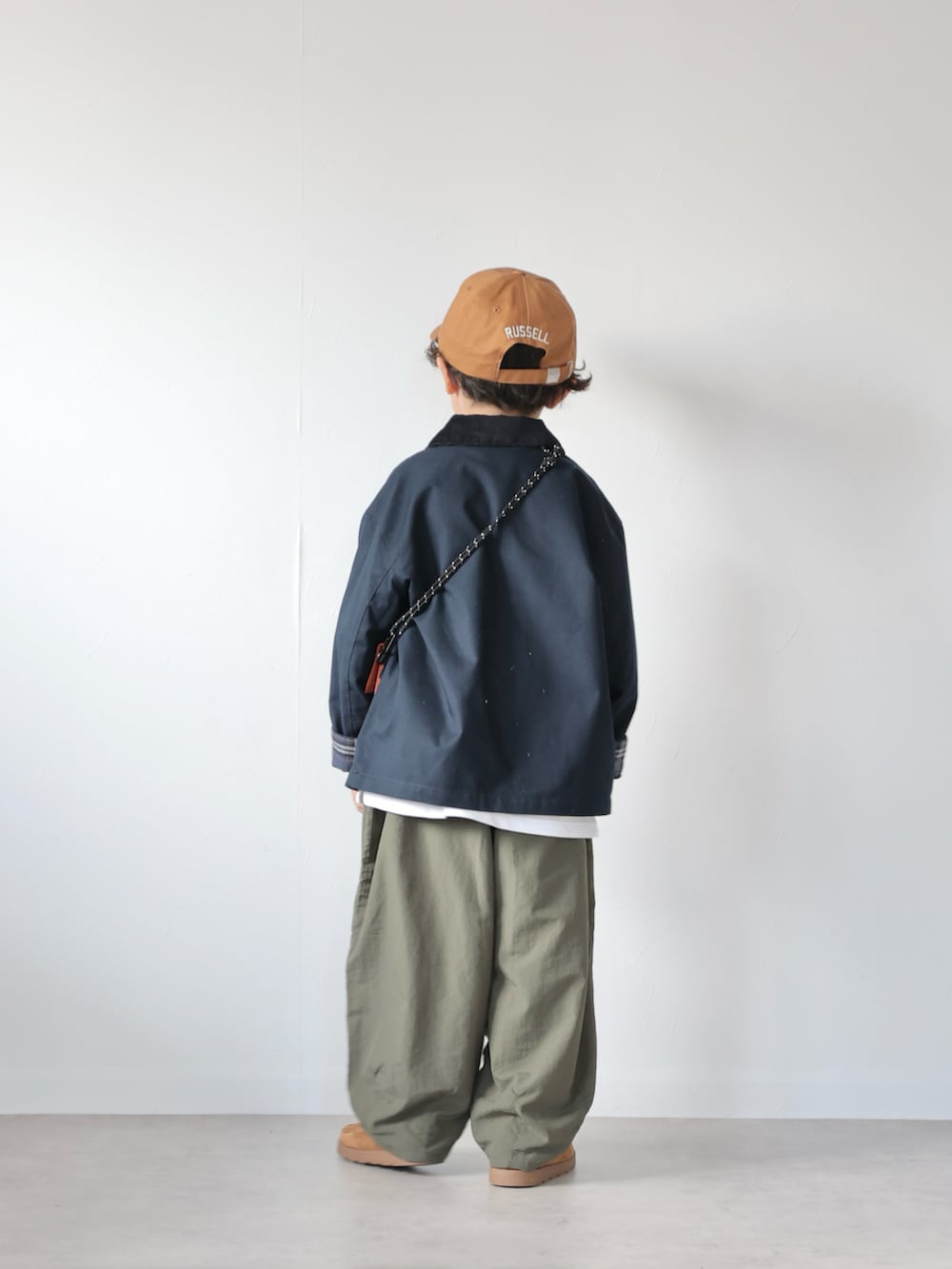 ブルー系のジャケット/アウター、ブラック系のトップス、グリーン系のその他パンツを着用したキッズの秋コーディネートの3枚目の写真