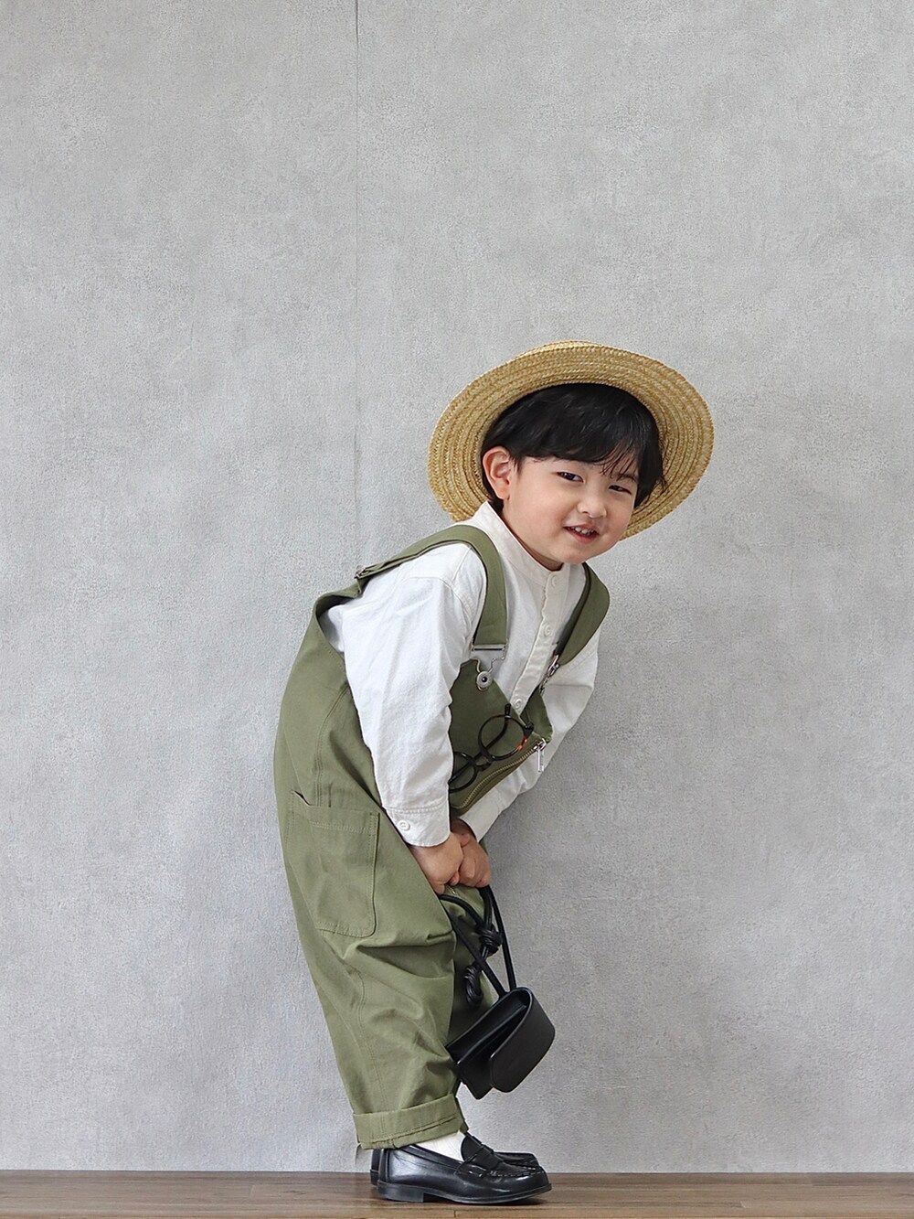 グリーン系のサロペット/オーバーオール、ホワイト系のシャツ/ブラウス、ブラック系のローファーを着用したキッズの春コーディネートの3枚目の写真