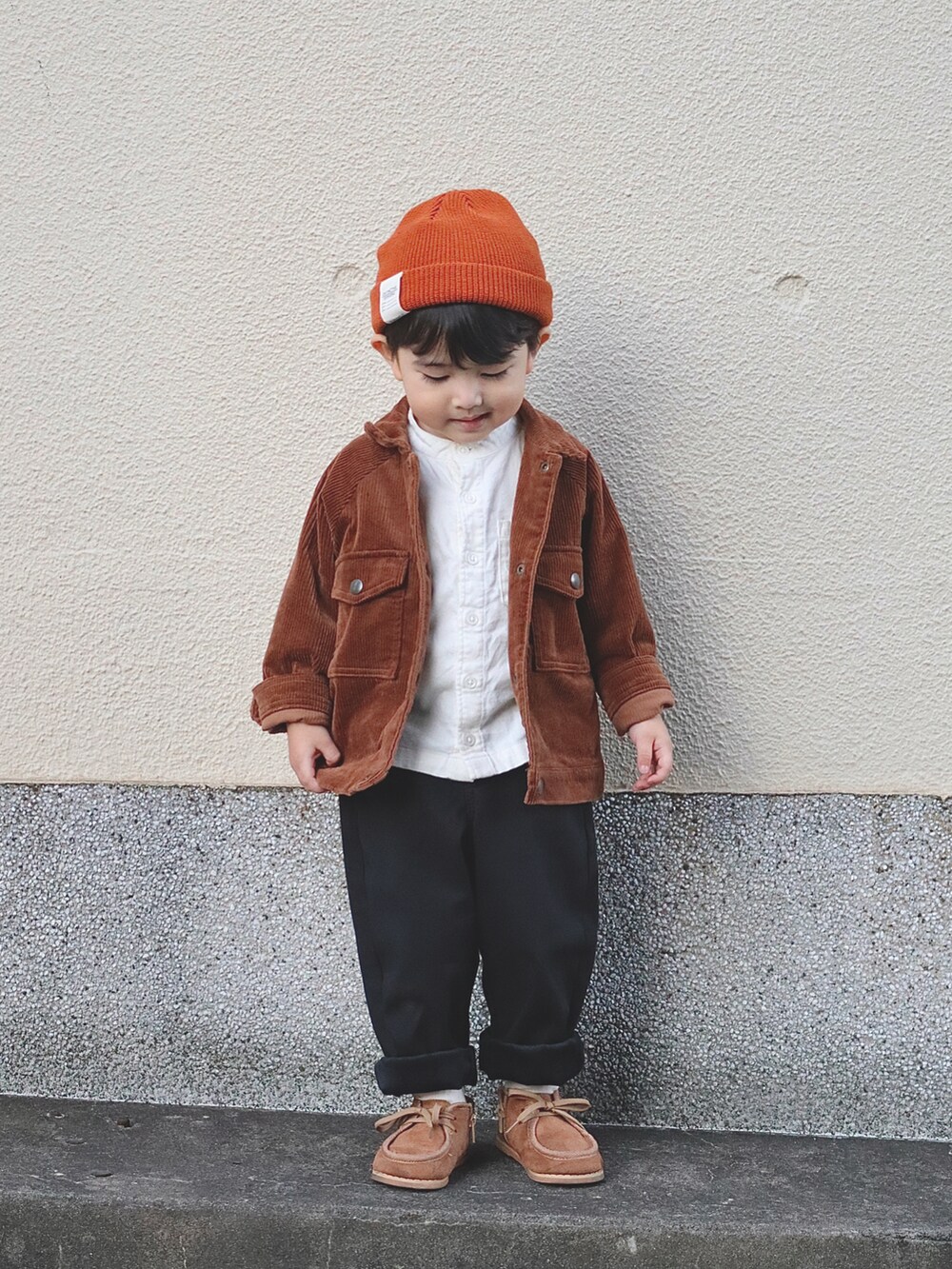 ブラウン系のブルゾン、ホワイト系のシャツ/ブラウス、ブラック系のその他パンツを着用したキッズの秋コーディネートの2枚目の写真