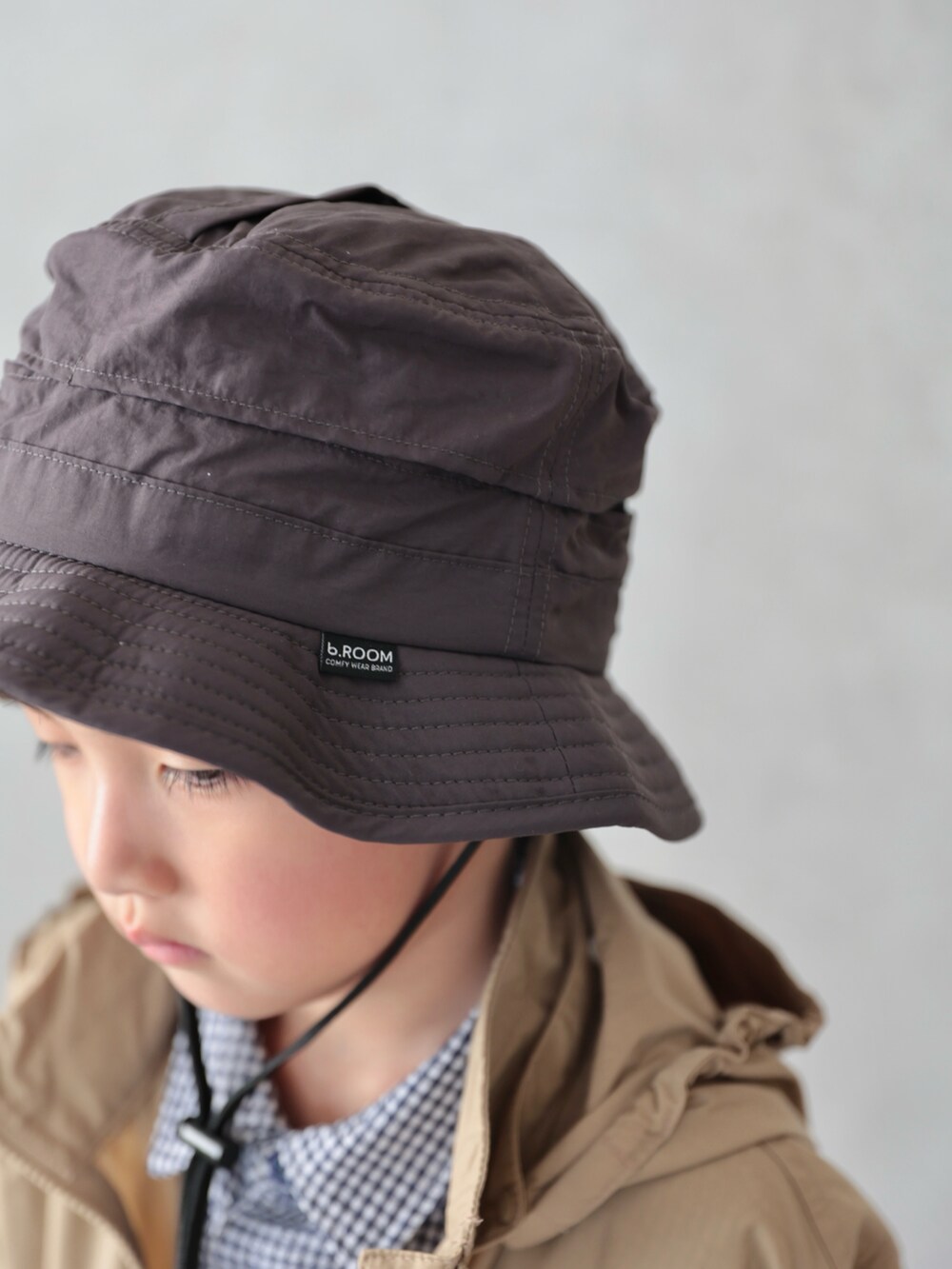 ベージュ系のブルゾン、ブルー系のシャツ/ブラウス、ブラック系のパンツを着用したキッズの冬コーディネートの5枚目の写真