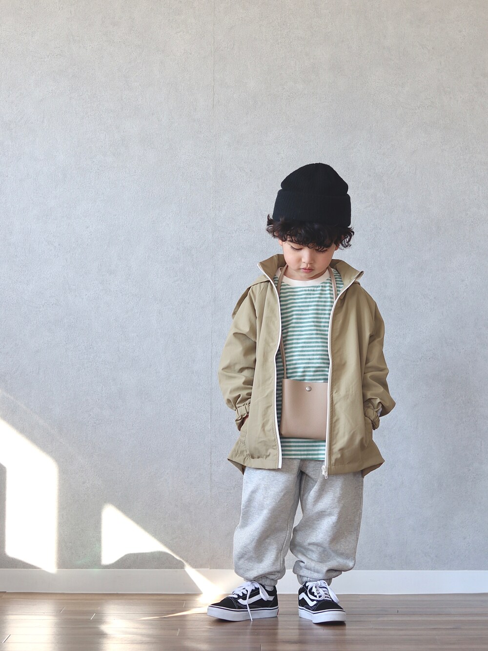 グリーン系のTシャツ/カットソー、ホワイト系のスウェットパンツ、ベージュ系のショルダーバッグを着用したキッズの冬コーディネートの2枚目の写真