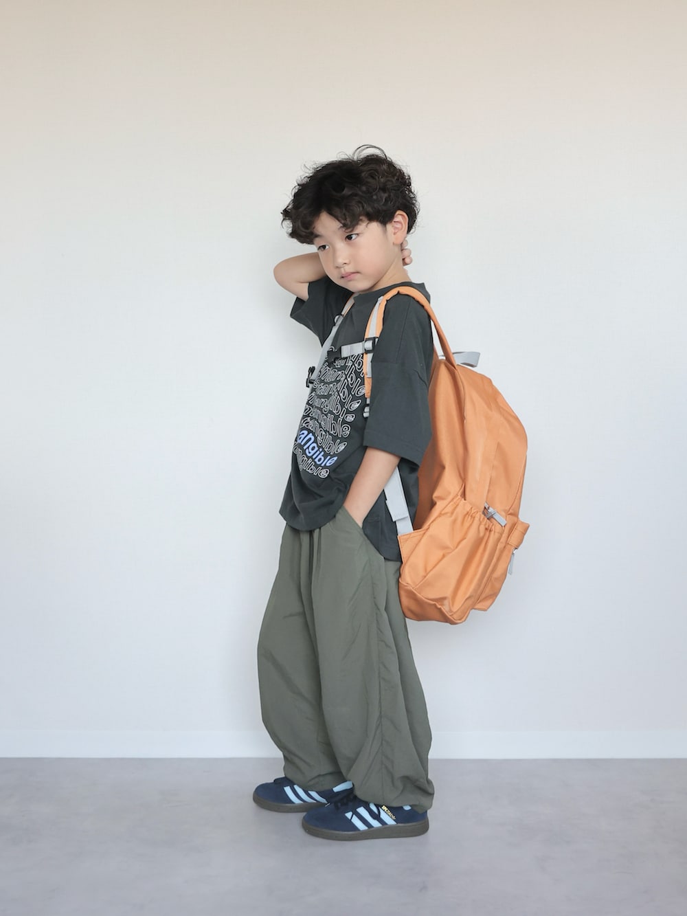 ブラック系のTシャツ/カットソー、グリーン系のその他パンツ、オレンジ系のバックパック/リュックを着用したキッズの夏コーディネートの4枚目の写真