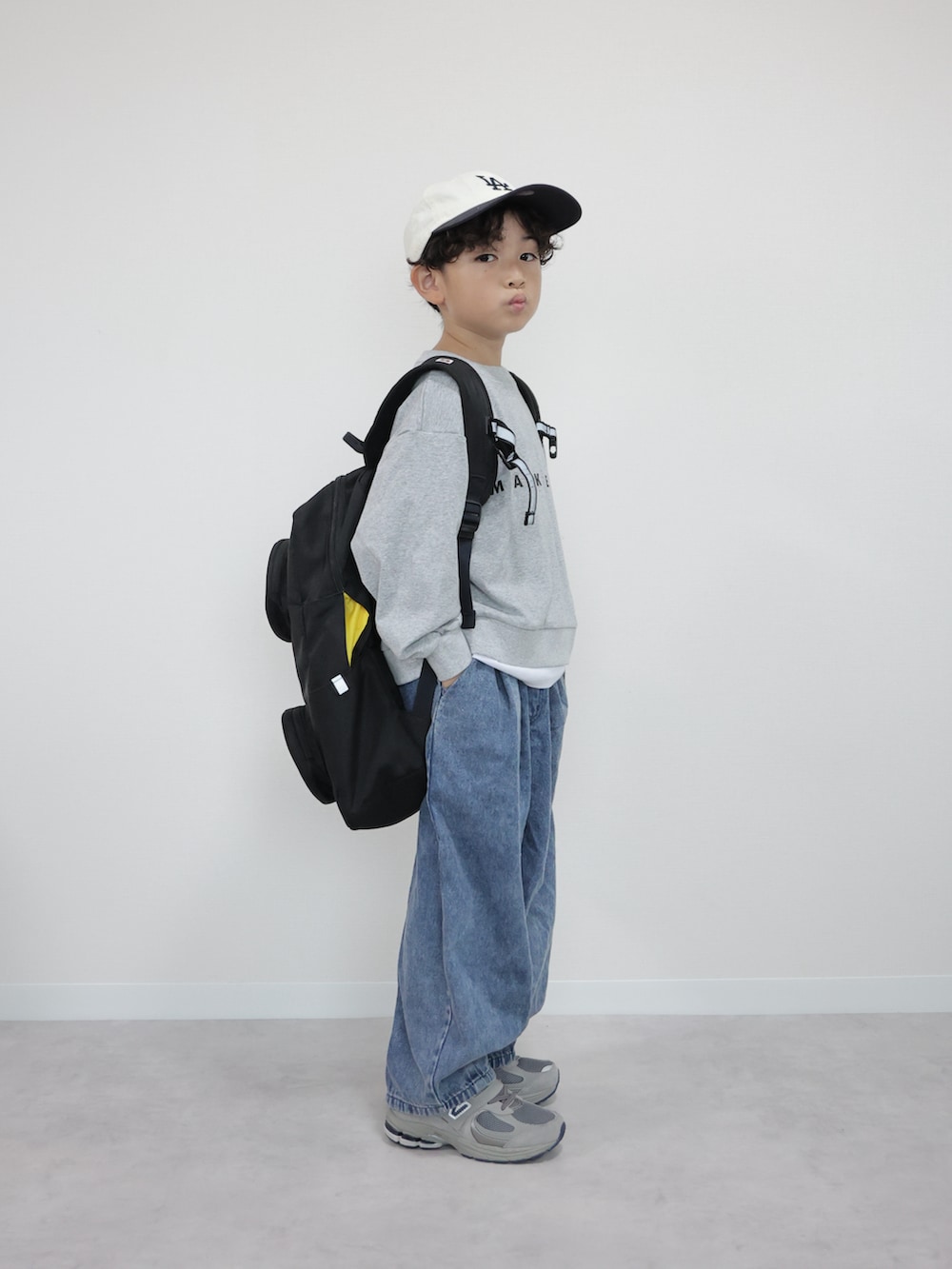 グレー系のTシャツ/カットソー、ブルー系のデニムパンツ、グレー系のスニーカーを着用したキッズの秋コーディネートの2枚目の写真