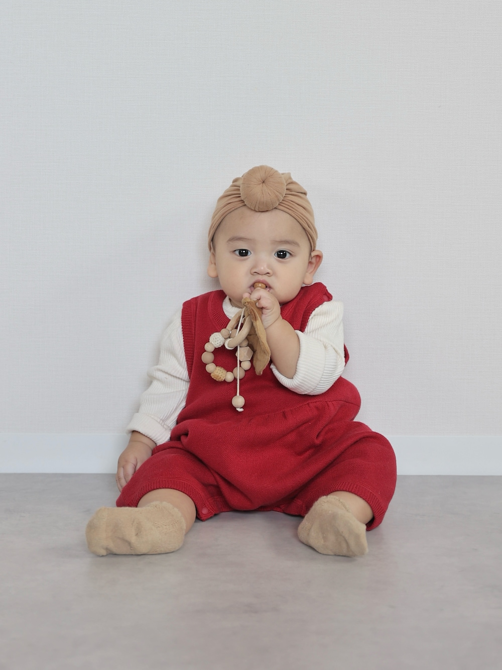 レッド系のニット/セーター、ベージュ系のその他パンツ、ブラウン系のモカシン/デッキシューズを着用したキッズの秋コーディネートの3枚目の写真