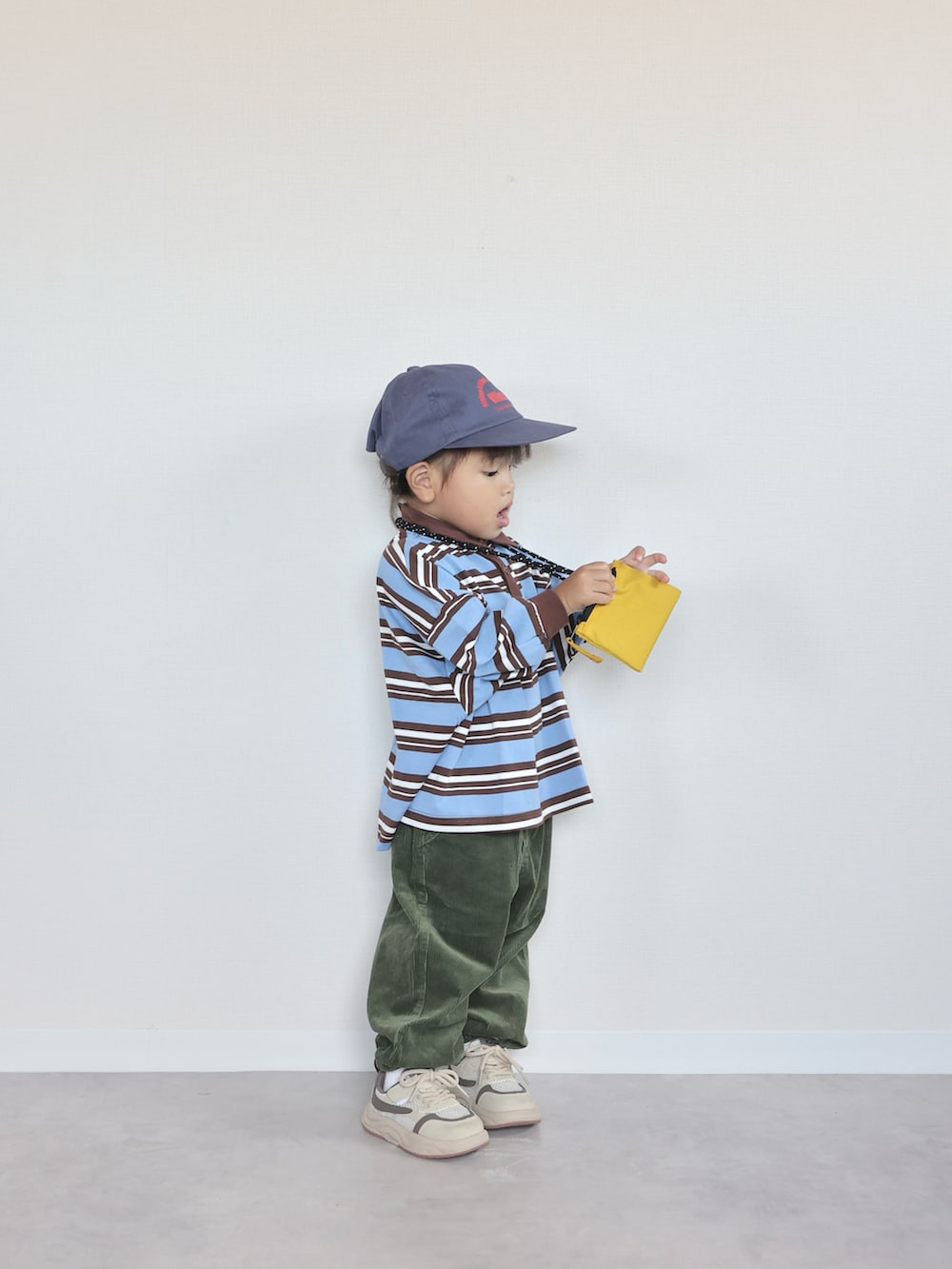 ベージュ系のスニーカー、グリーン系のパンツ、ブルー系のTシャツ/カットソーを着用したキッズの秋コーディネートの2枚目の写真