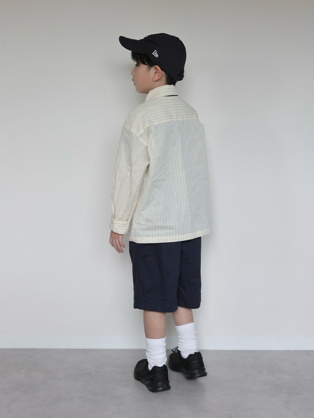 イエロー系のシャツ/ブラウス、ブラック系のスニーカー、ブルー系のパンツを着用したキッズの春コーディネートの3枚目の写真