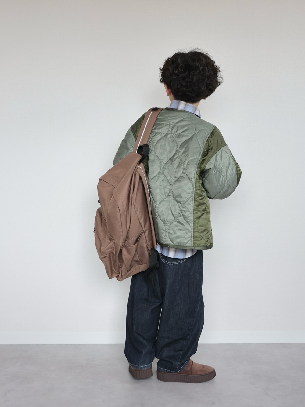 ブルー系のシャツ/ブラウス、グリーン系のブルゾン、ブラウン系のバックパック/リュックを着用したキッズの秋コーディネートの3枚目の写真