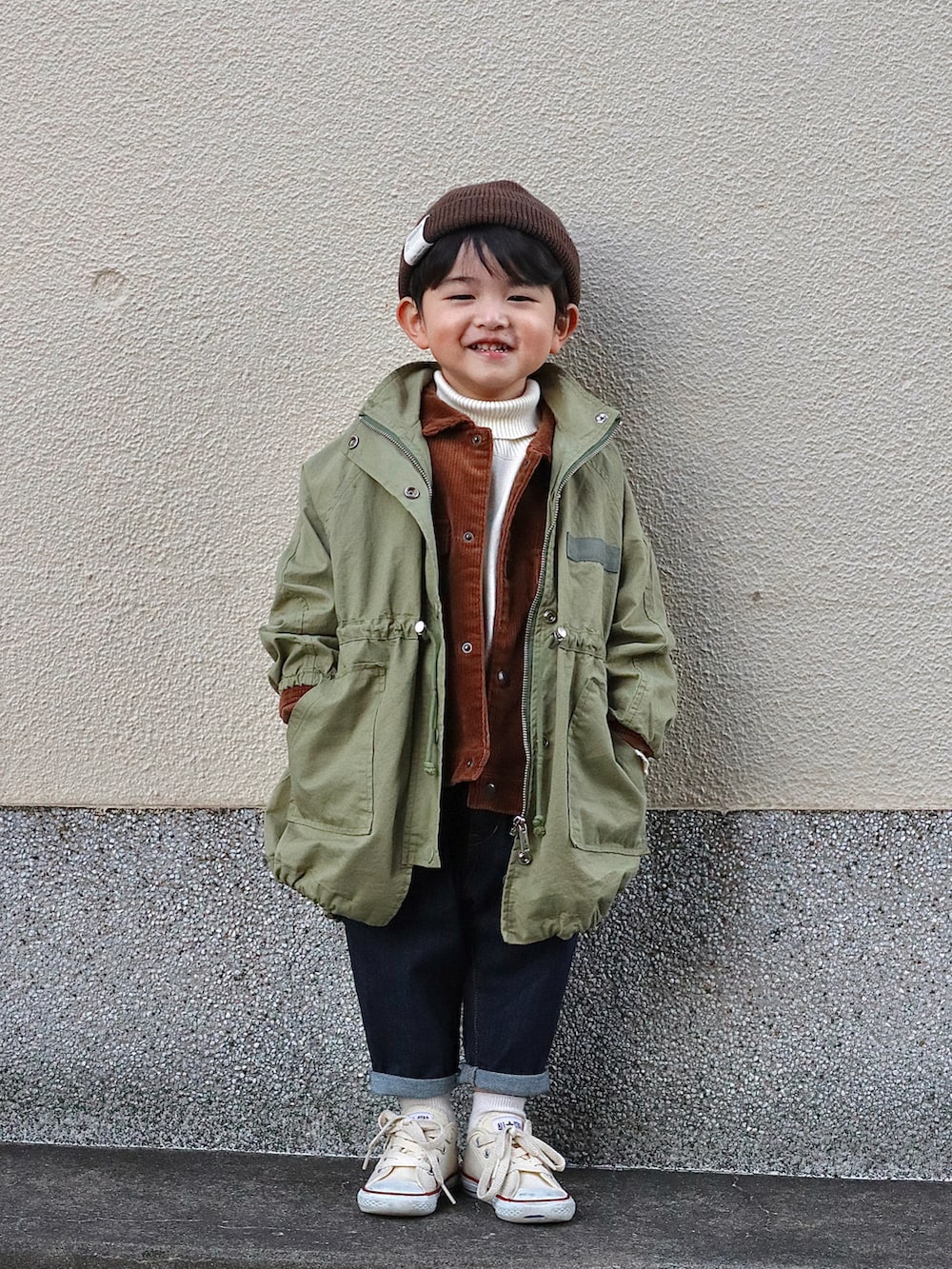 グリーン系のジャケット/アウター、ブラウン系のブルゾン、ホワイト系のニット/セーターを着用したキッズの冬コーディネートの3枚目の写真