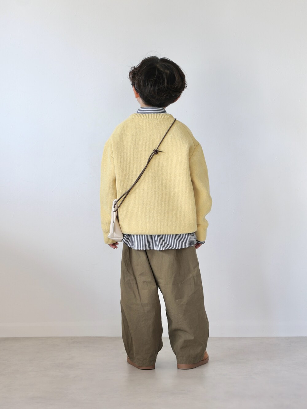イエロー系のニット/セーター、ブラック系のシャツ/ブラウス、グリーン系のカーゴパンツを着用したキッズの冬コーディネートの4枚目の写真