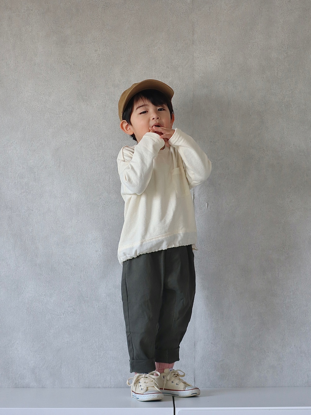 ブラウン系のカーディガン/ボレロ、ホワイト系のTシャツ/カットソー、グリーン系のその他パンツを着用したキッズの冬コーディネートの3枚目の写真