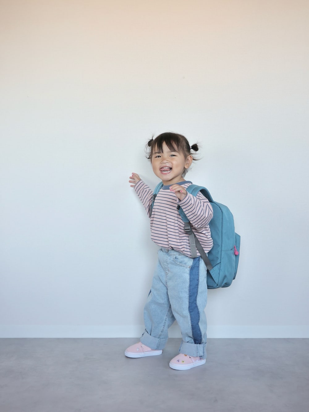 ピンク系のTシャツ/カットソー、ブルー系のデニムパンツ、ピンク系のスニーカーを着用したキッズの秋コーディネートの3枚目の写真