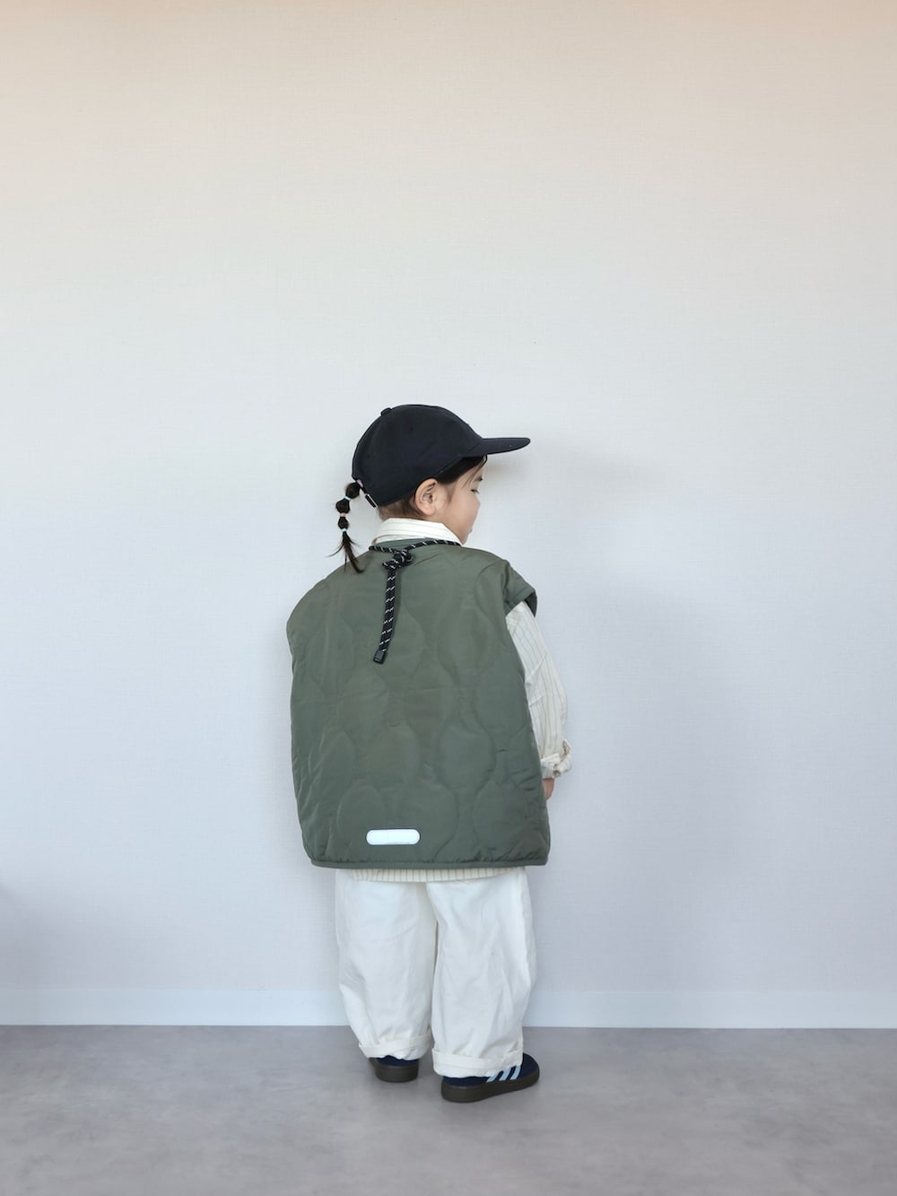 グリーン系のベスト、イエロー系のシャツ/ブラウス、ブルー系のスニーカーを着用したキッズの春コーディネートの4枚目の写真