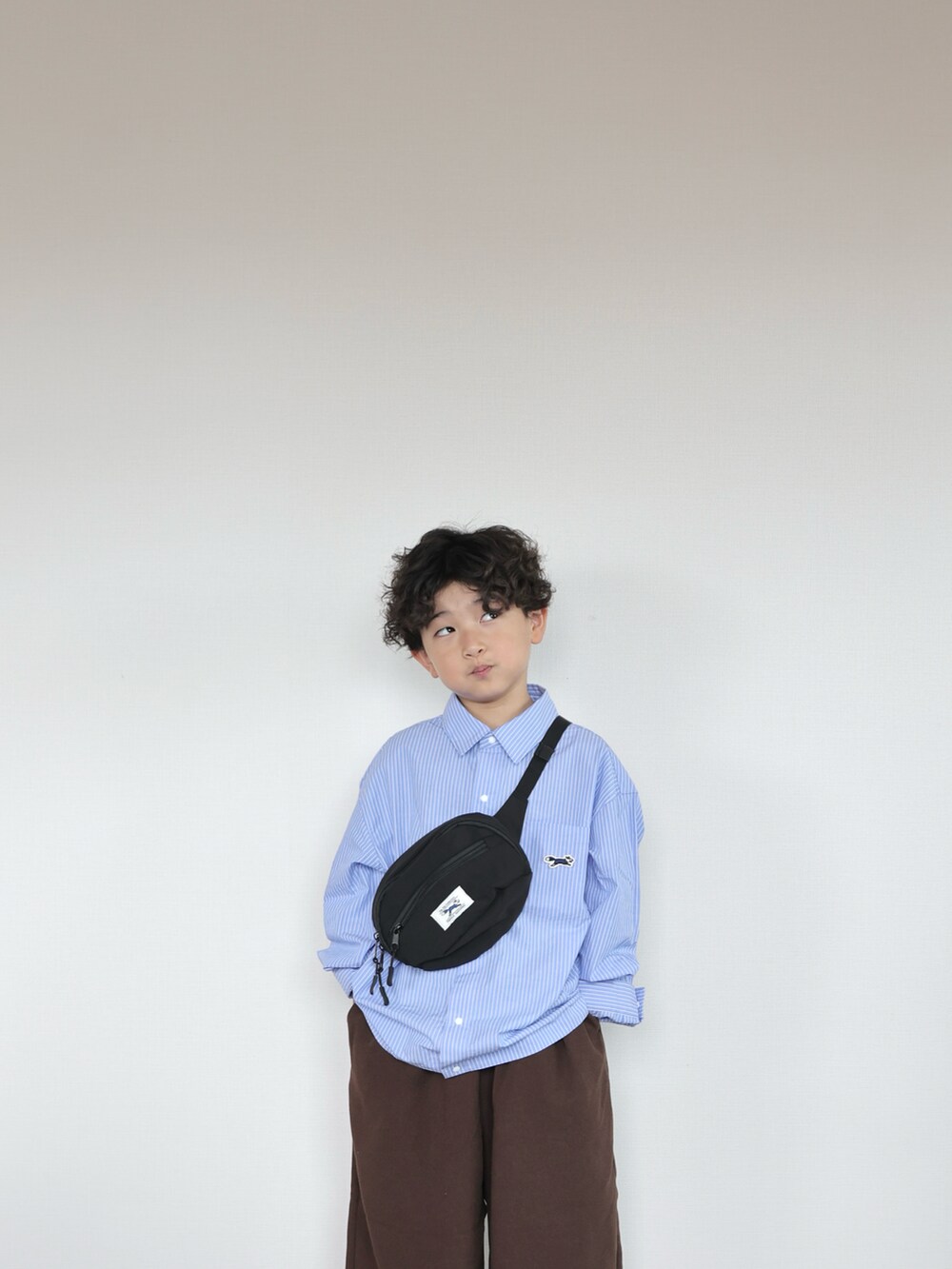 ブルー系のシャツ/ブラウス、ブラウン系のその他パンツ、グレー系のスニーカーを着用したキッズの秋コーディネートの5枚目の写真