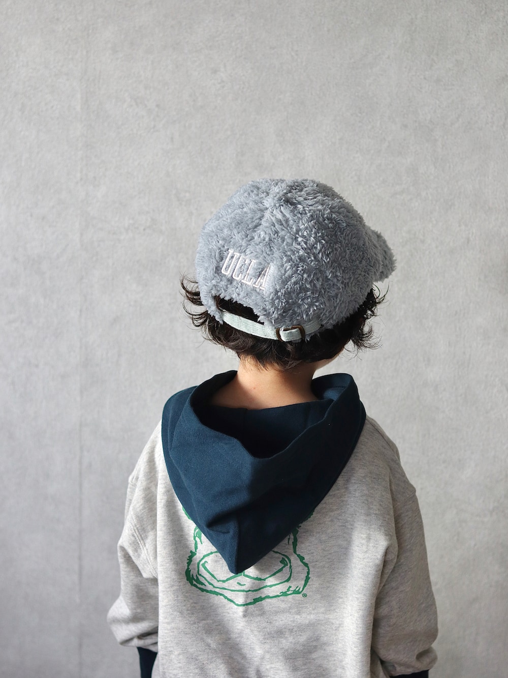 ホワイト系のパーカー、ブルー系のデニムパンツ、グリーン系のスニーカーを着用したキッズの秋コーディネートの2枚目の写真