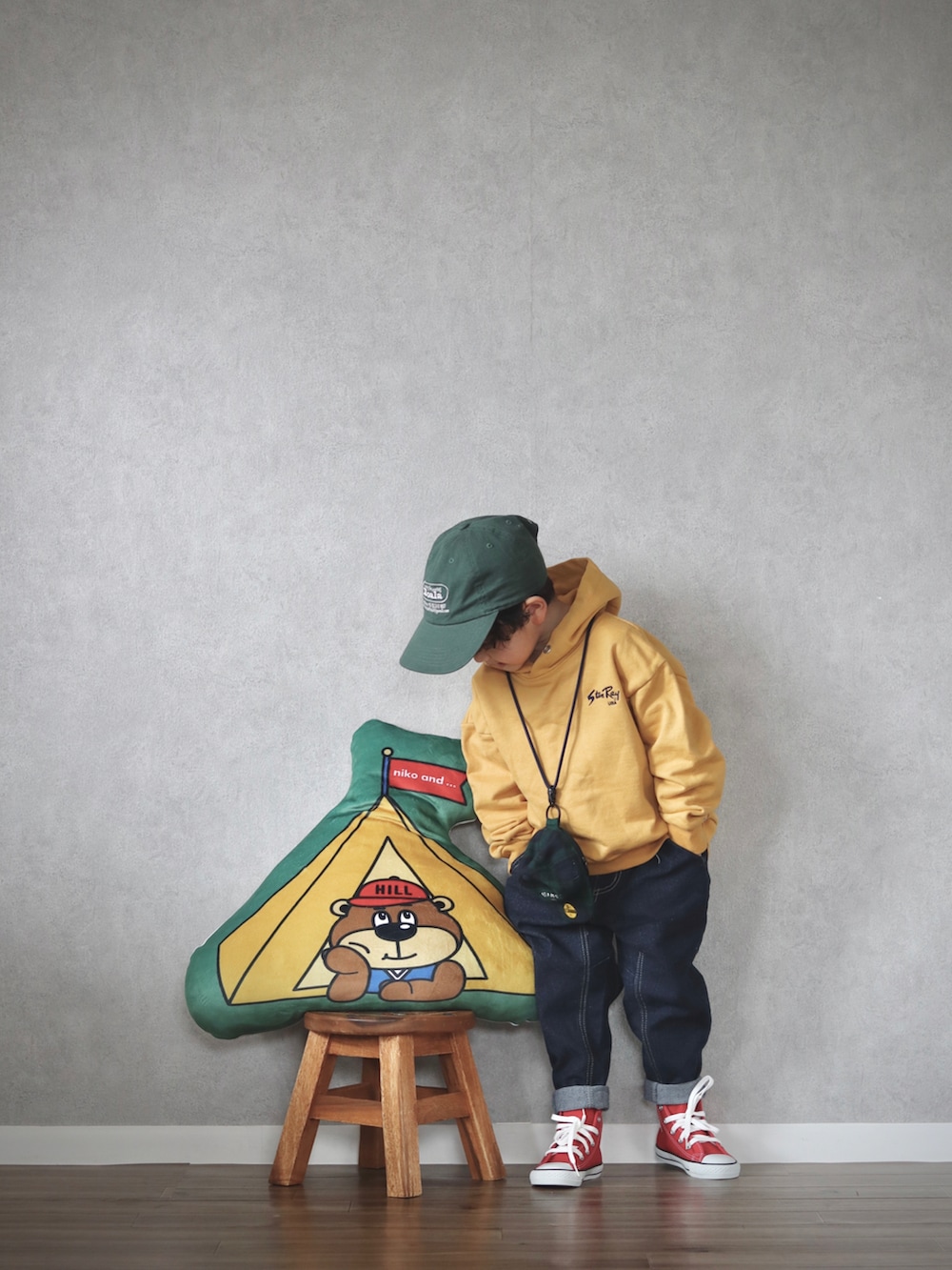 イエロー系のパーカー、ブルー系のデニムパンツ、レッド系のスニーカーを着用したキッズの春コーディネートの2枚目の写真