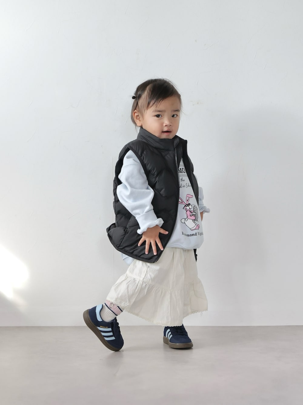 ブルー系のスウェット、ホワイト系のスカート、ブルー系のスニーカーを着用したキッズの冬コーディネートの4枚目の写真