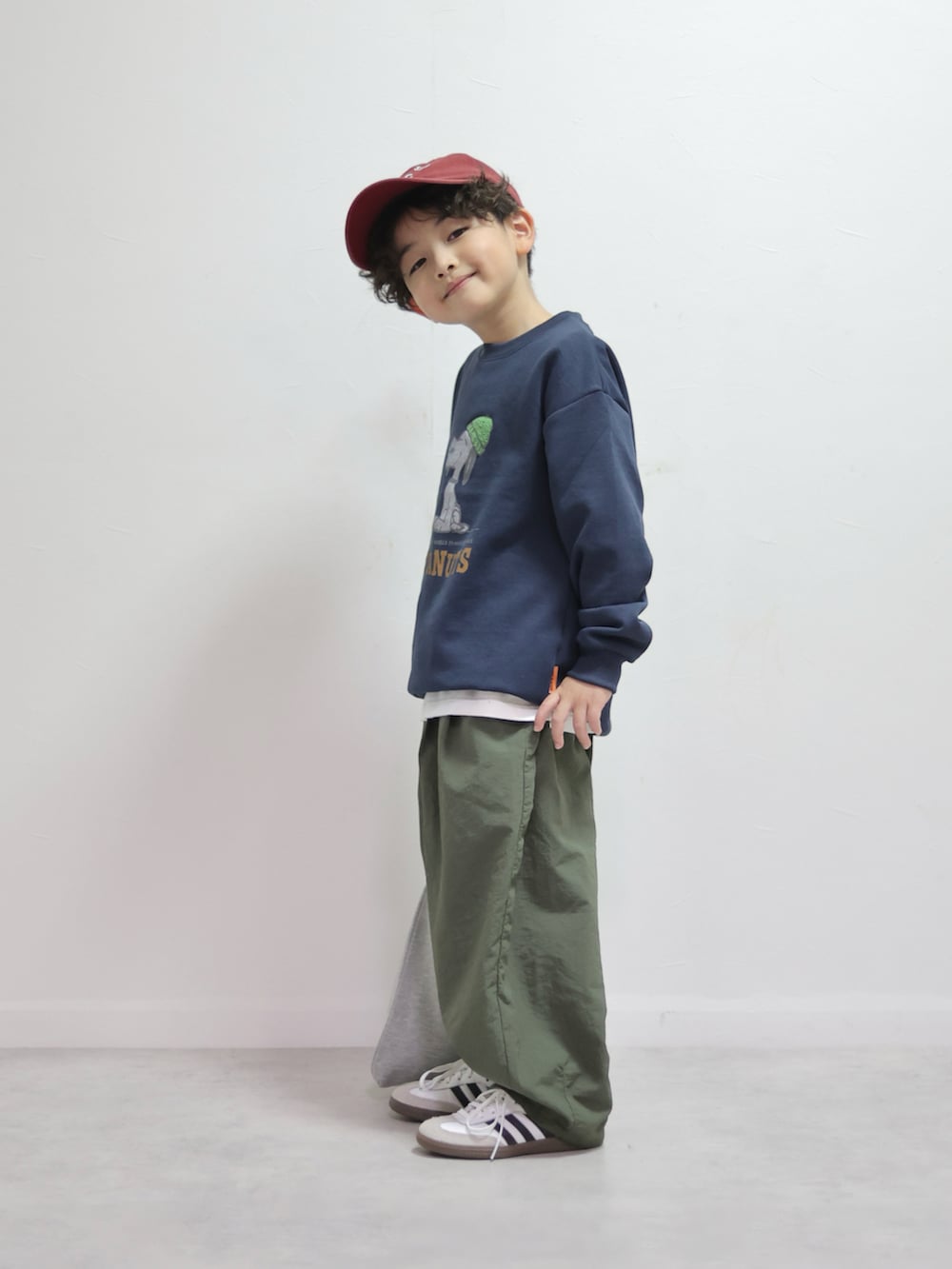 ブルー系のスウェット、グリーン系のその他パンツ、グレー系のハンドバッグを着用したキッズの冬コーディネートの2枚目の写真