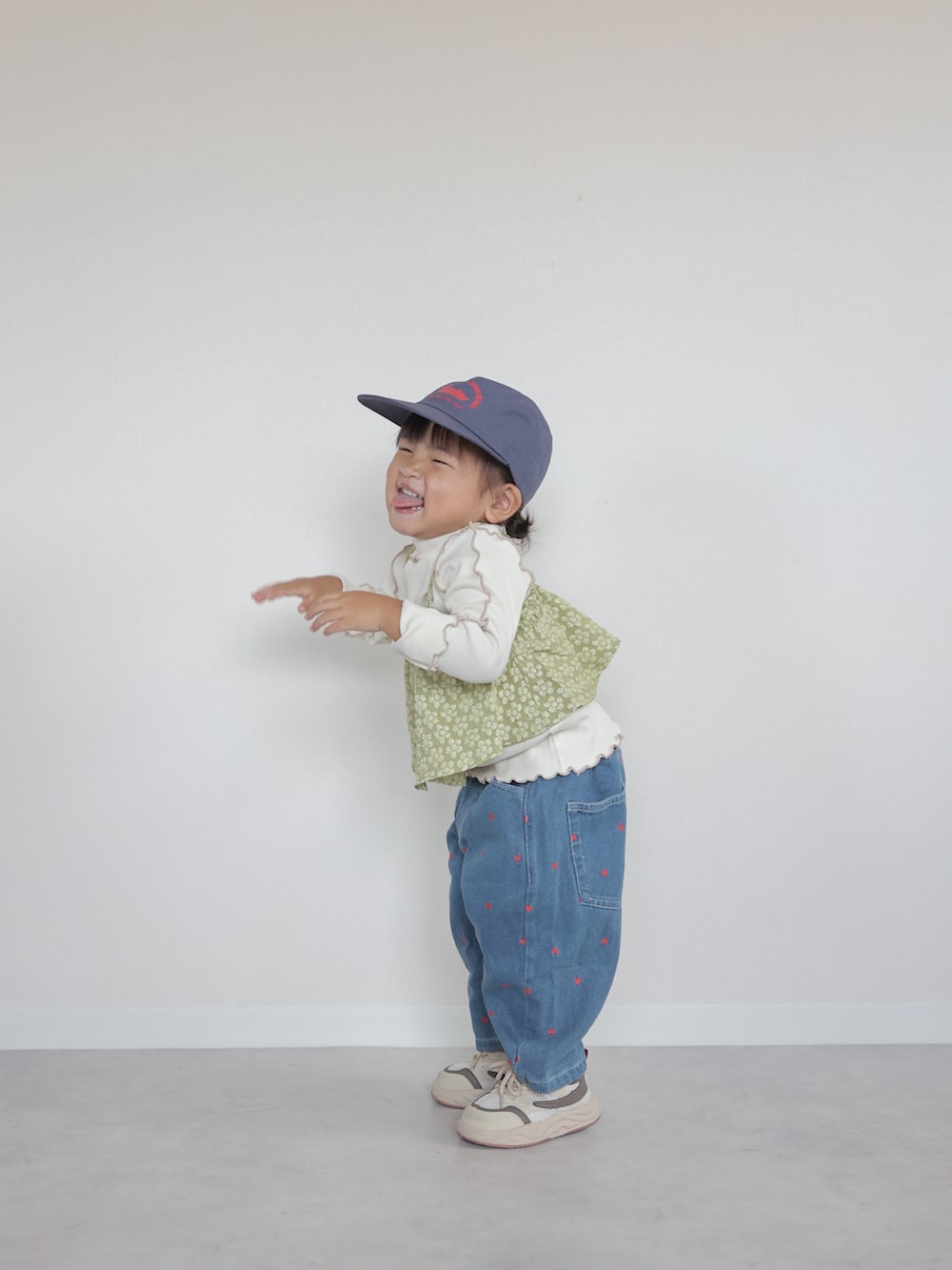 ベージュ系のスニーカー、グリーン系のTシャツ/カットソー、ブルー系のデニムパンツを着用したキッズの夏コーディネートの4枚目の写真