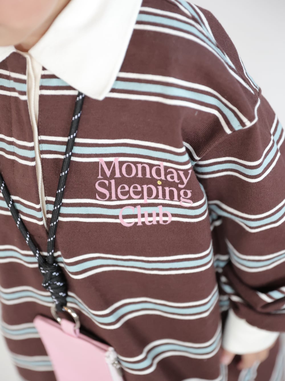 ブラウン系のポロシャツ、ホワイト系のスニーカー、ホワイト系のスカートを着用したキッズの春コーディネートの3枚目の写真