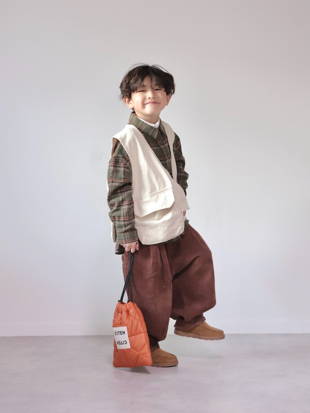 グリーン系のシャツ/ブラウス、ホワイト系のベスト、ホワイト系のTシャツ/カットソーを着用したキッズの冬コーディネートの2枚目の写真