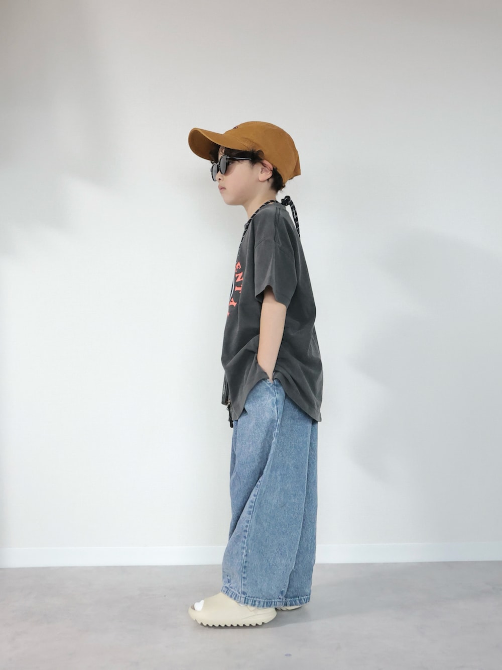 グレー系のTシャツ/カットソー、ブルー系のデニムパンツ、ベージュ系のサンダルを着用したキッズの夏コーディネートの2枚目の写真