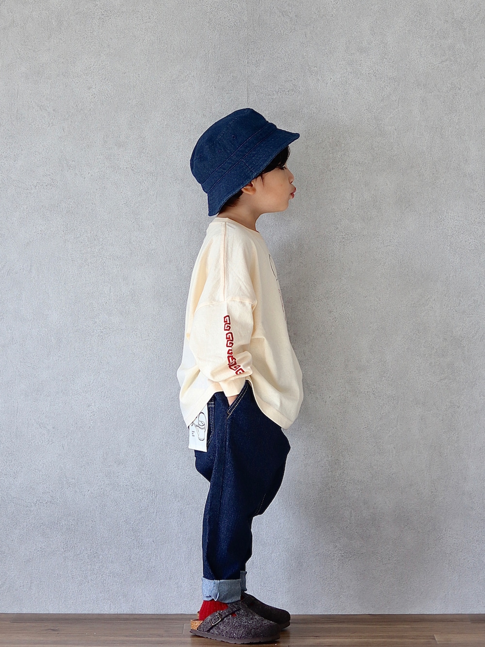 ホワイト系のTシャツ/カットソー、ブルー系のデニムパンツ、グレー系のシューズを着用したキッズの秋コーディネートの3枚目の写真