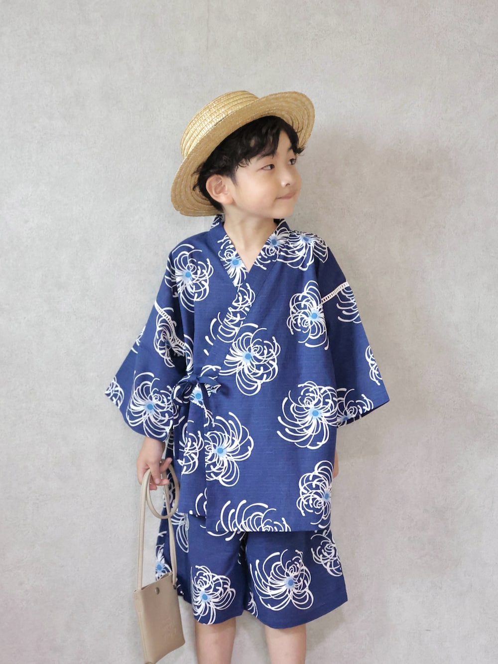 ベージュ系のサンダル、ベージュ系のショルダーバッグ、その他の帽子を着用したキッズの夏コーディネートの2枚目の写真