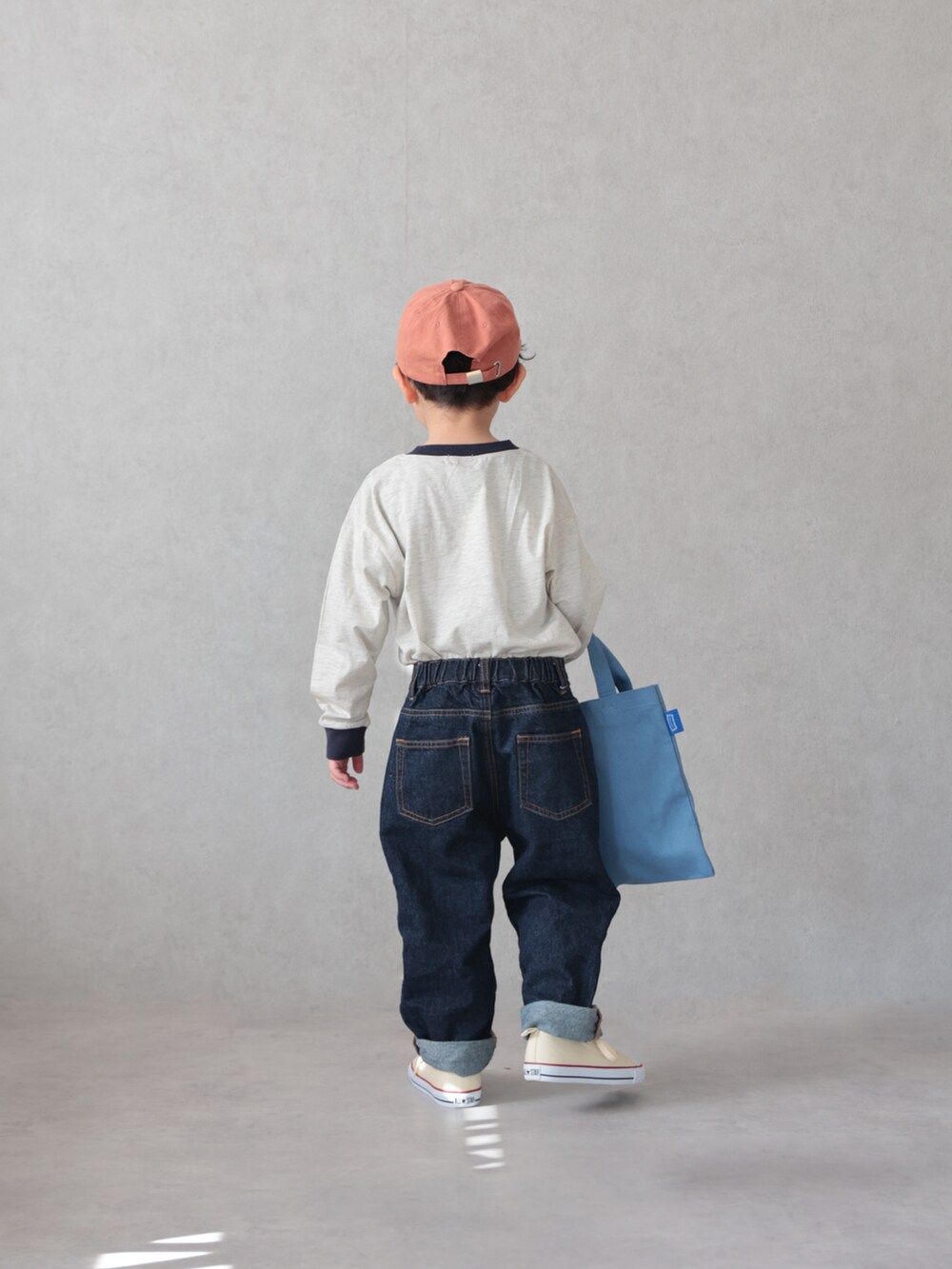 ベージュ系のTシャツ/カットソー、ブルー系のデニムパンツ、ホワイト系のスニーカーを着用したキッズの春コーディネートの2枚目の写真