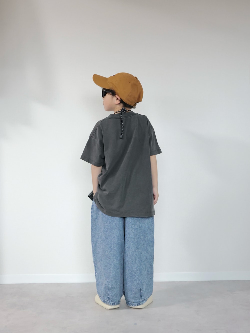 グレー系のTシャツ/カットソー、ブルー系のデニムパンツ、ベージュ系のサンダルを着用したキッズの夏コーディネートの4枚目の写真