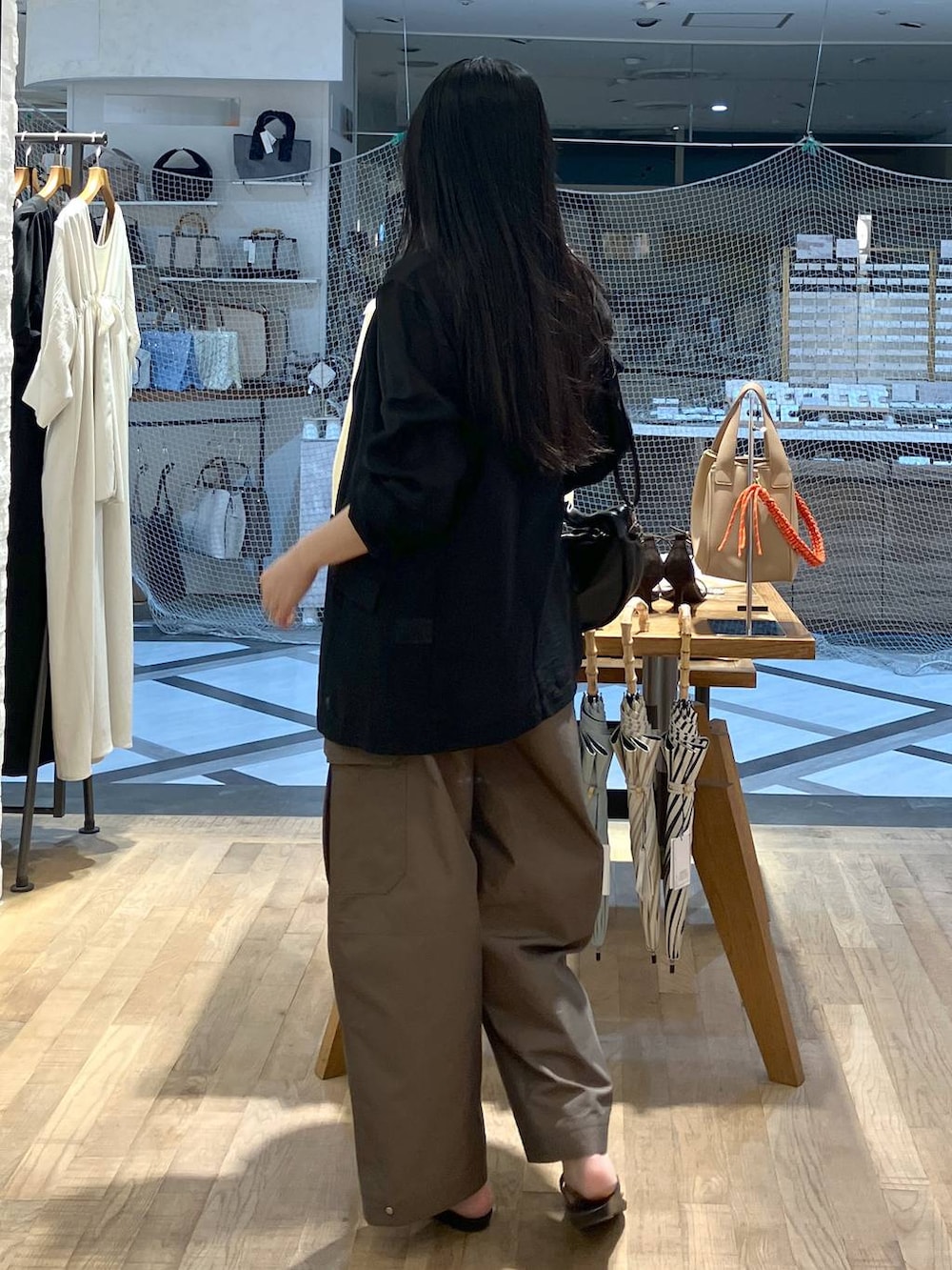 ブラック系のハンドバッグ、ブラック系のテーラードジャケット、ブラック系のキャミソールを着用したレディースの夏コーディネートの3枚目の写真