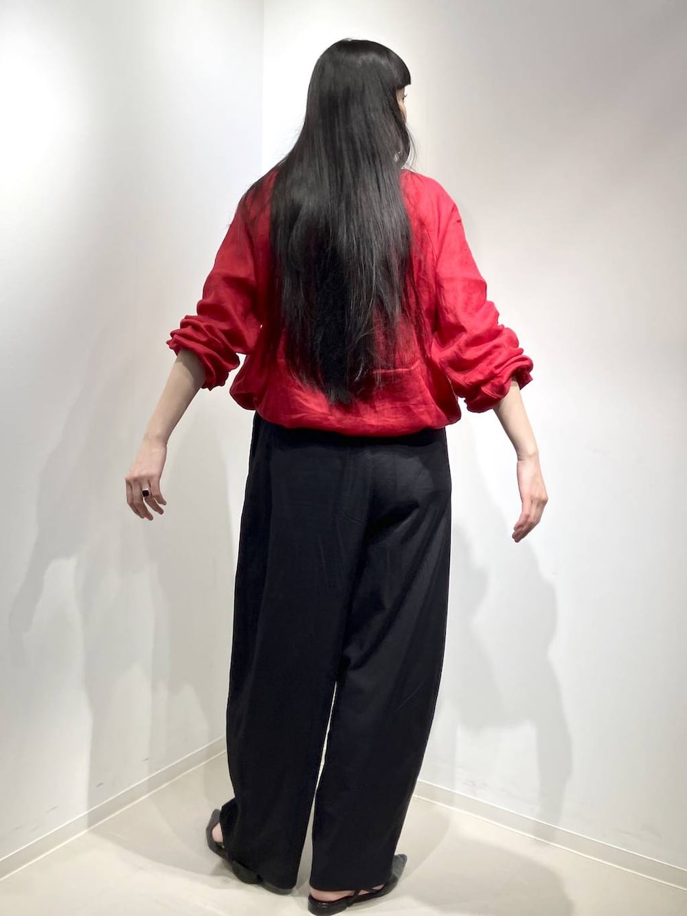 レッド系のブルゾン、ブラック系のその他パンツを着用したレディースの春コーディネートの3枚目の写真