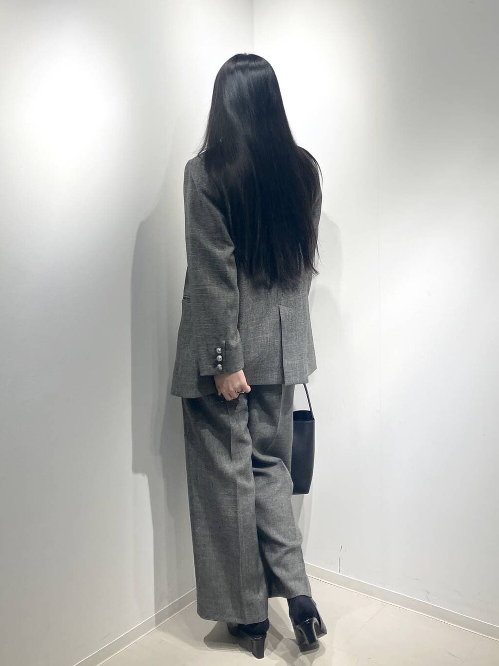 ブラック系のスラックス、ブラック系のテーラードジャケット、ブラック系のパンプスを着用したレディースの冬コーディネートの3枚目の写真