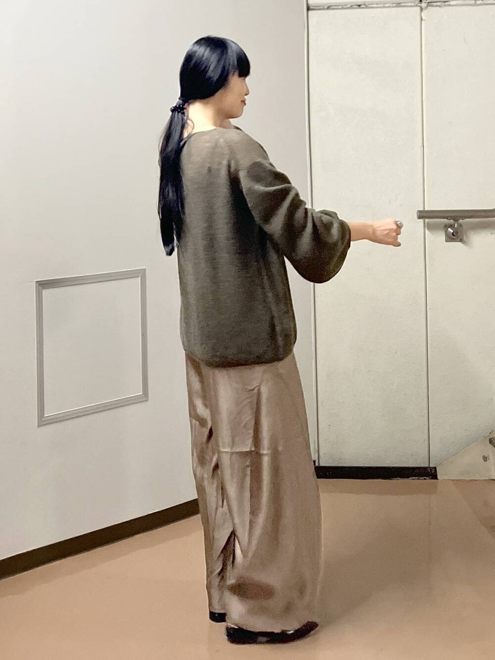 ブラウン系のニット/セーター、ブラック系のタンクトップ、ブラウン系のその他パンツを着用したレディースの秋コーディネートの2枚目の写真