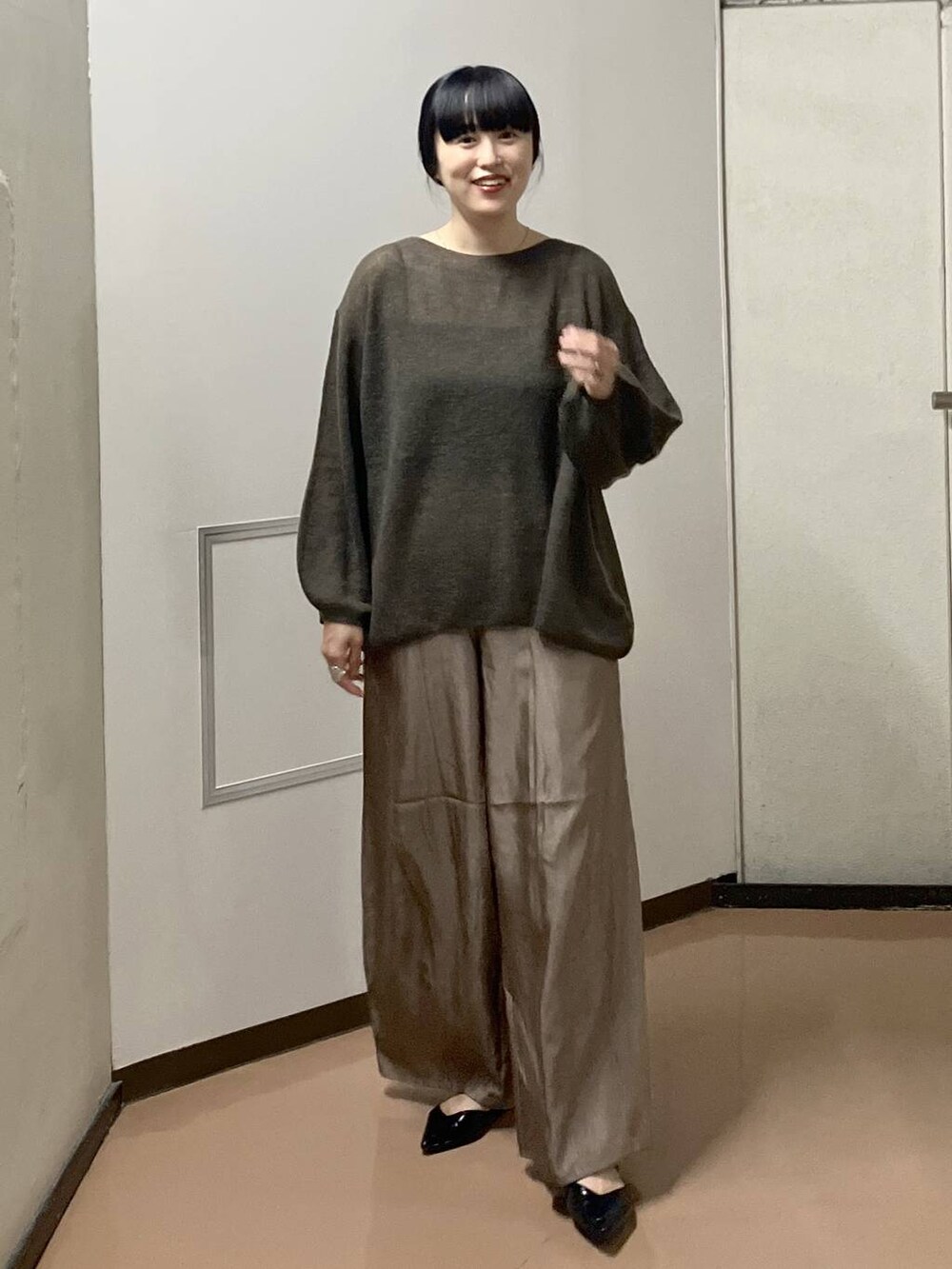 ブラウン系のニット/セーター、ブラック系のタンクトップ、ブラウン系のその他パンツを着用したレディースの秋コーディネートの5枚目の写真