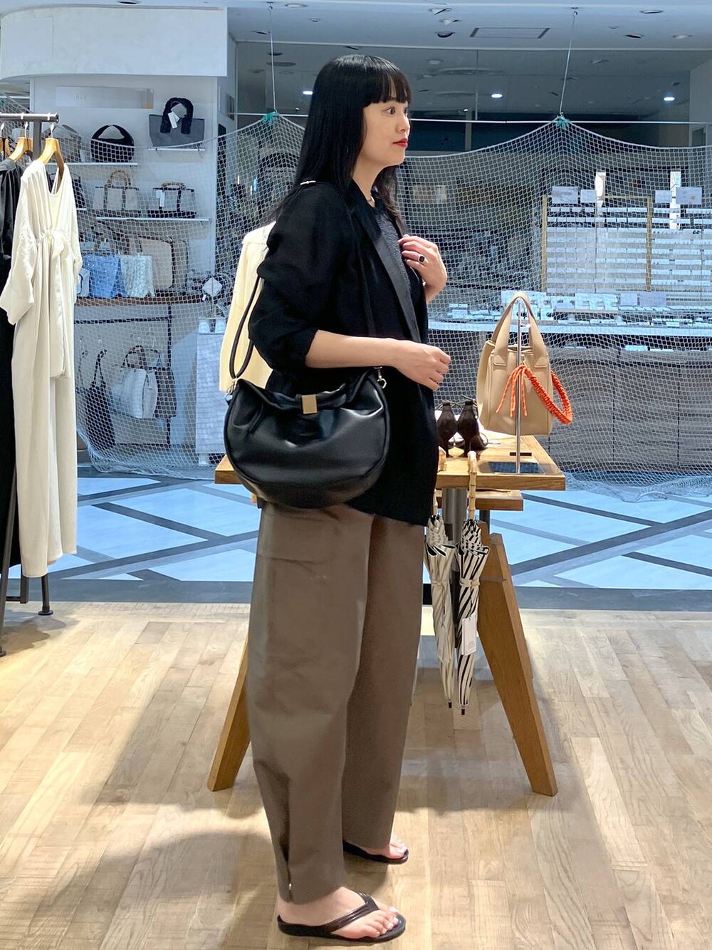 ブラック系のハンドバッグ、ブラック系のテーラードジャケット、ブラック系のキャミソールを着用したレディースの夏コーディネートの2枚目の写真