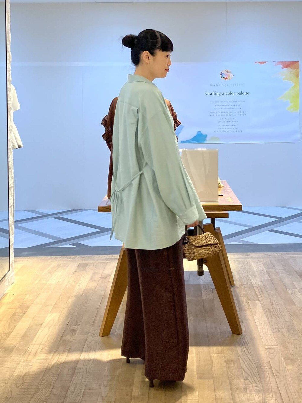 ブラウン系のその他パンツ、ブラウン系のショルダーバッグ、グリーン系のシャツ/ブラウスを着用したレディースの夏コーディネートの2枚目の写真