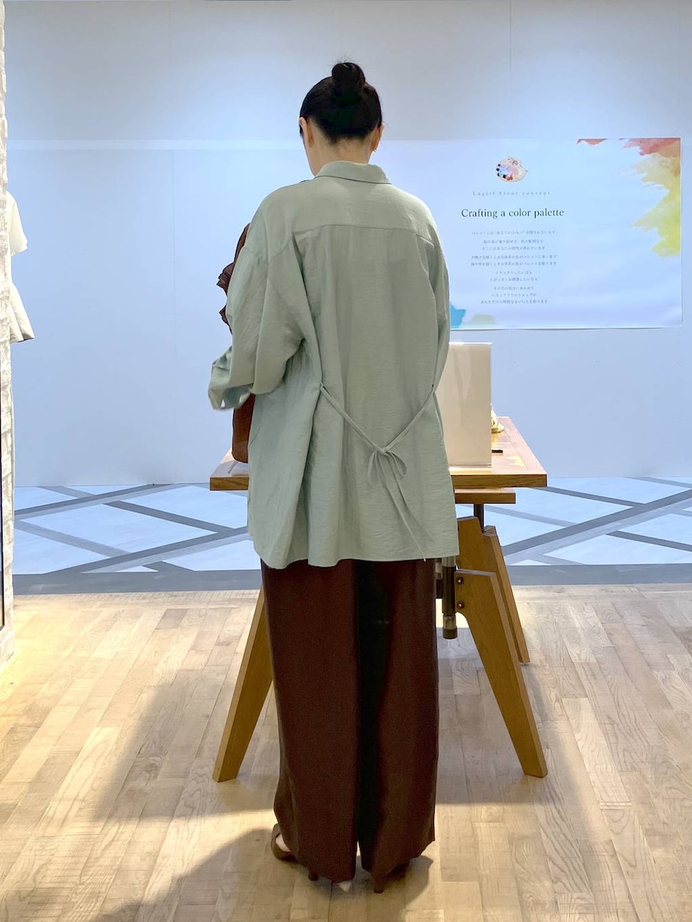 ブラウン系のその他パンツ、ブラウン系のショルダーバッグ、グリーン系のシャツ/ブラウスを着用したレディースの夏コーディネートの3枚目の写真