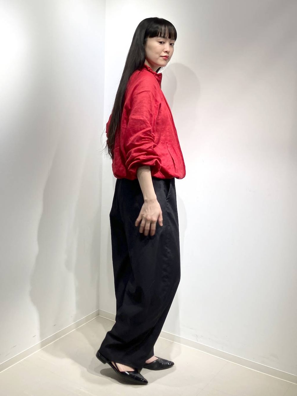 レッド系のブルゾン、ブラック系のその他パンツを着用したレディースの春コーディネートの2枚目の写真