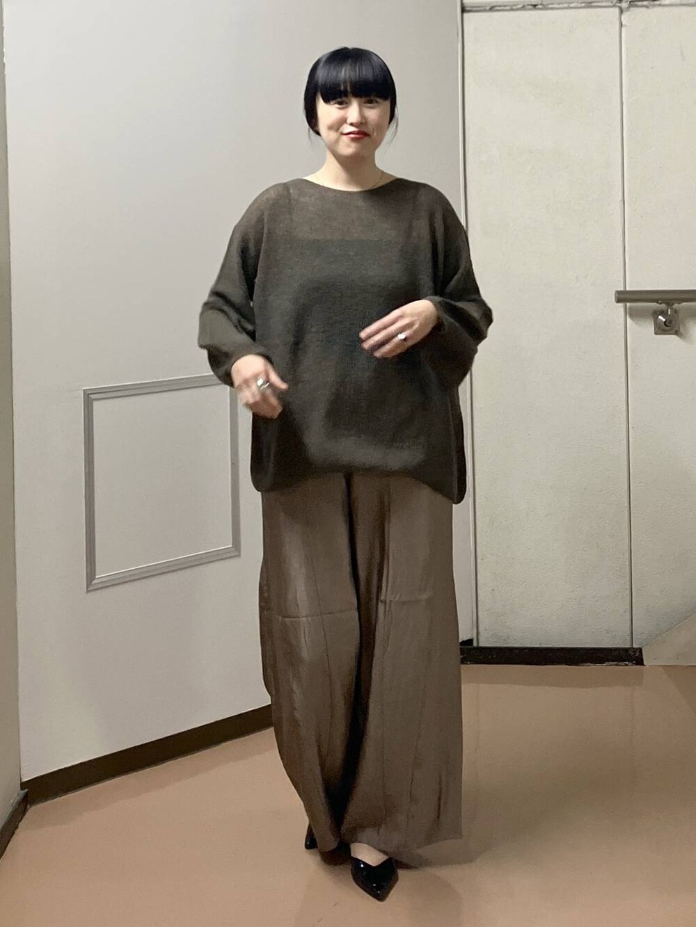 ブラウン系のニット/セーター、ブラック系のタンクトップ、ブラウン系のその他パンツを着用したレディースの秋コーディネートの4枚目の写真