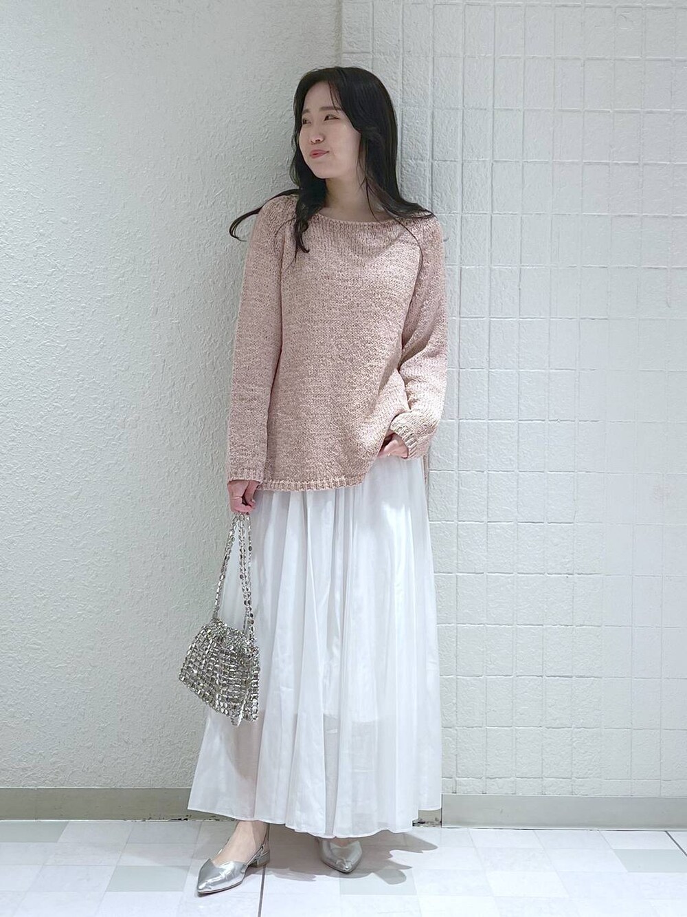 ホワイト系のスカート、シルバー系のショルダーバッグ、シルバー系のパンプスを着用したレディースの冬コーディネートの3枚目の写真
