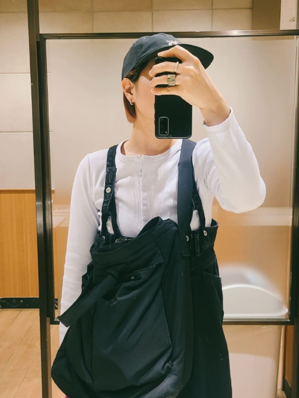 ブラック系のバッグ、ブラック系のサロペット/オーバーオール、ブルー系のスニーカーを着用したレディースの春コーディネートの2枚目の写真