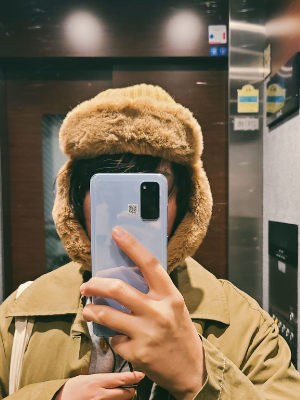 ブルー系のデニムパンツ、グレー系のスニーカー、グリーン系のステンカラーコートを着用したレディースの冬コーディネートの2枚目の写真