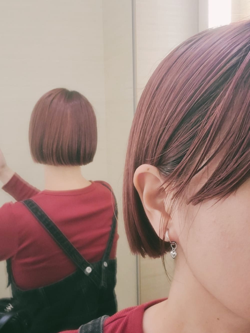 レッド系のTシャツ/カットソー、ブラック系のサロペット/オーバーオール、ブラック系のショルダーバッグを着用したレディースの秋コーディネートの2枚目の写真